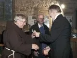 Zwei Männer reichen sich in der Kirche die Hand