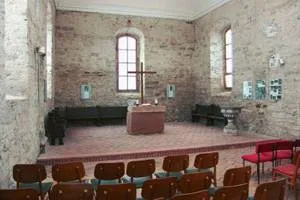 Innenraum der Wörmlitzer Kirche während des Wiederaufbaus mit Altar, Kreuz und roten Stühlen